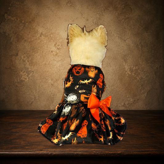 The Midnight Pumpkin Party Dress displayed on the approved antique plaster and walnut table
