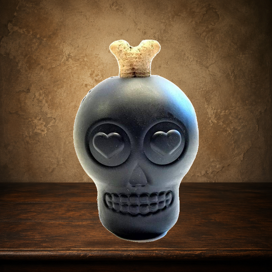 The Grinning Relic — Magnum Skull Treat Toy displayed on the approved antique plaster and walnut table