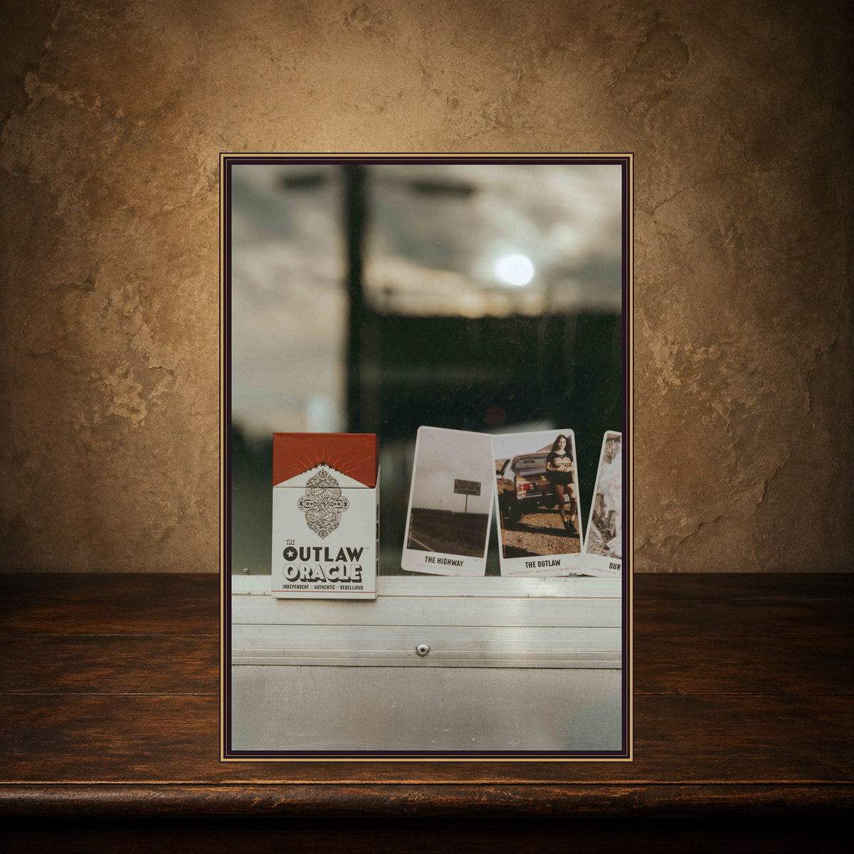 The Outlaw Intuition — Country & Western Oracle Deck displayed on the approved antique plaster and walnut table