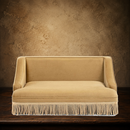 The Duchess yellow fringed pet sofa on the approved antique plaster and walnut backdrop