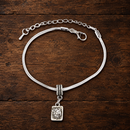 Pug charm bracelet resting on a walnut tabletop